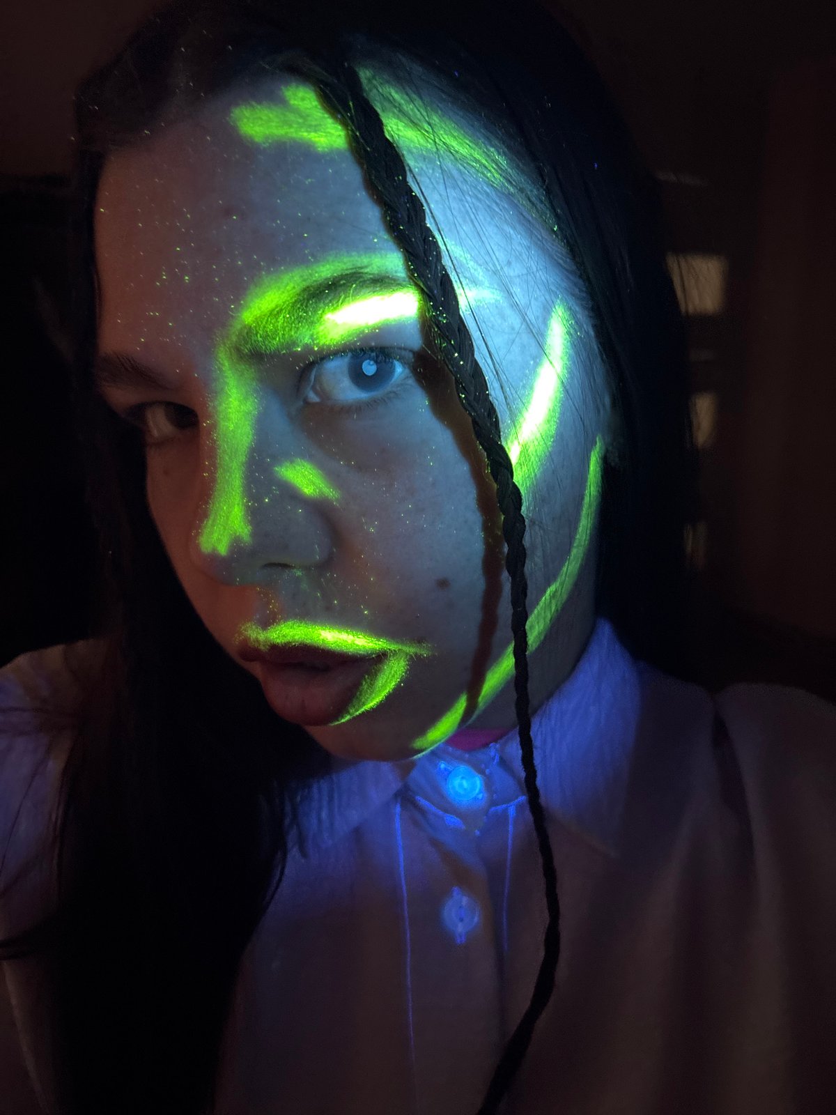 Person photographed with green face paint in Perm interior