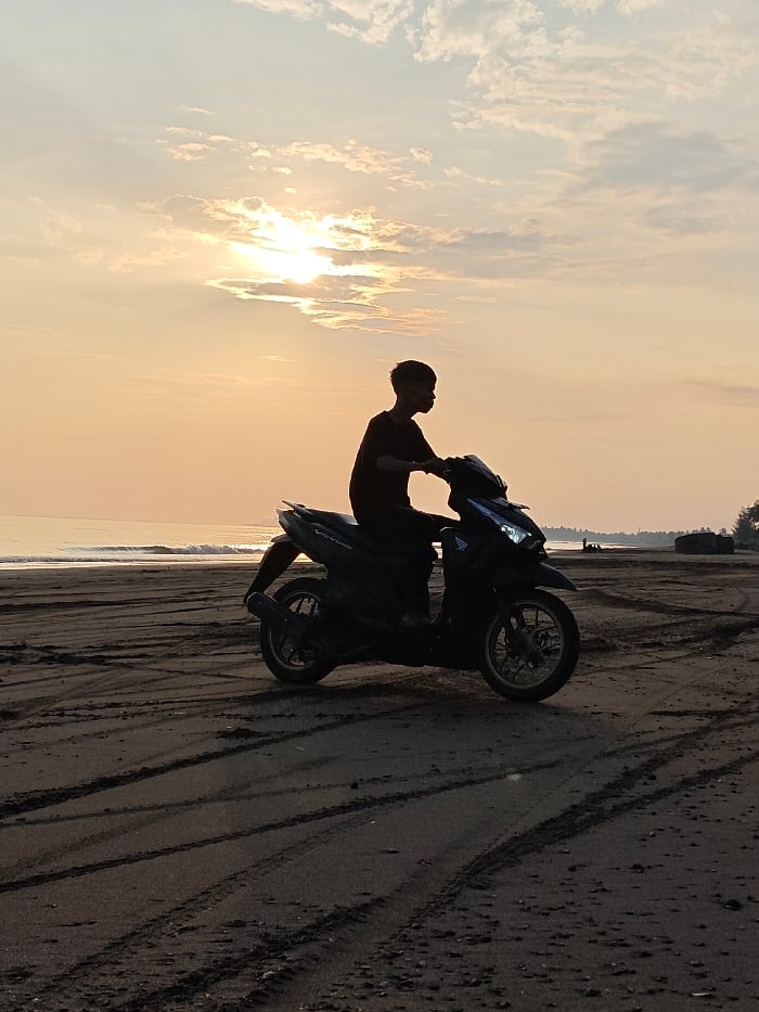 Beach sunrise witnessed by multiple visitors in Indonesia