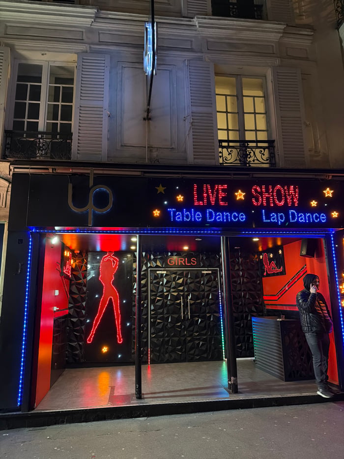Paris nightlife district bustling with illuminated venues, entertainment establishments