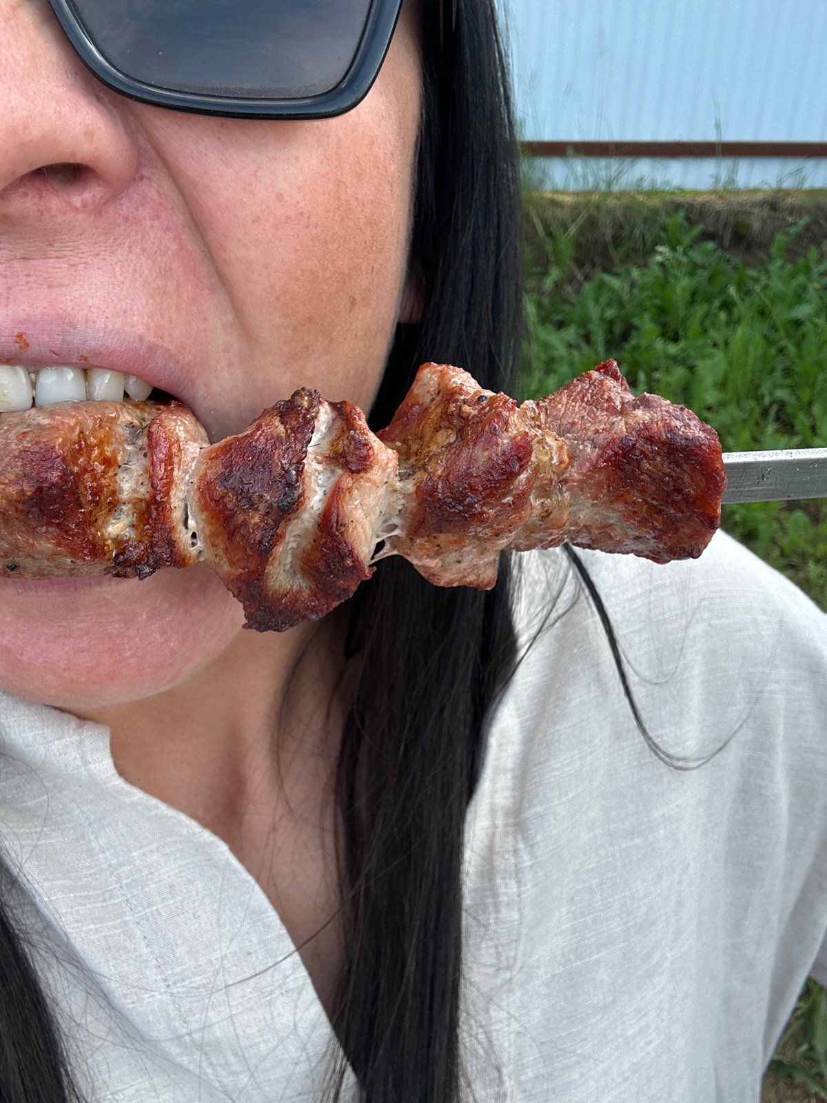 Friends gather for backyard barbecue with grilled skewers