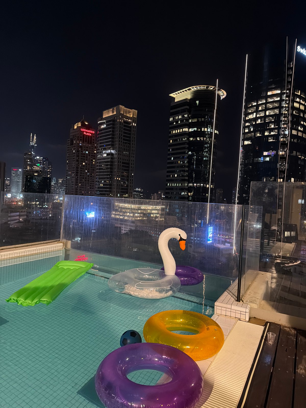 Rooftop pool night scene overlooking Ramat Gan skyline