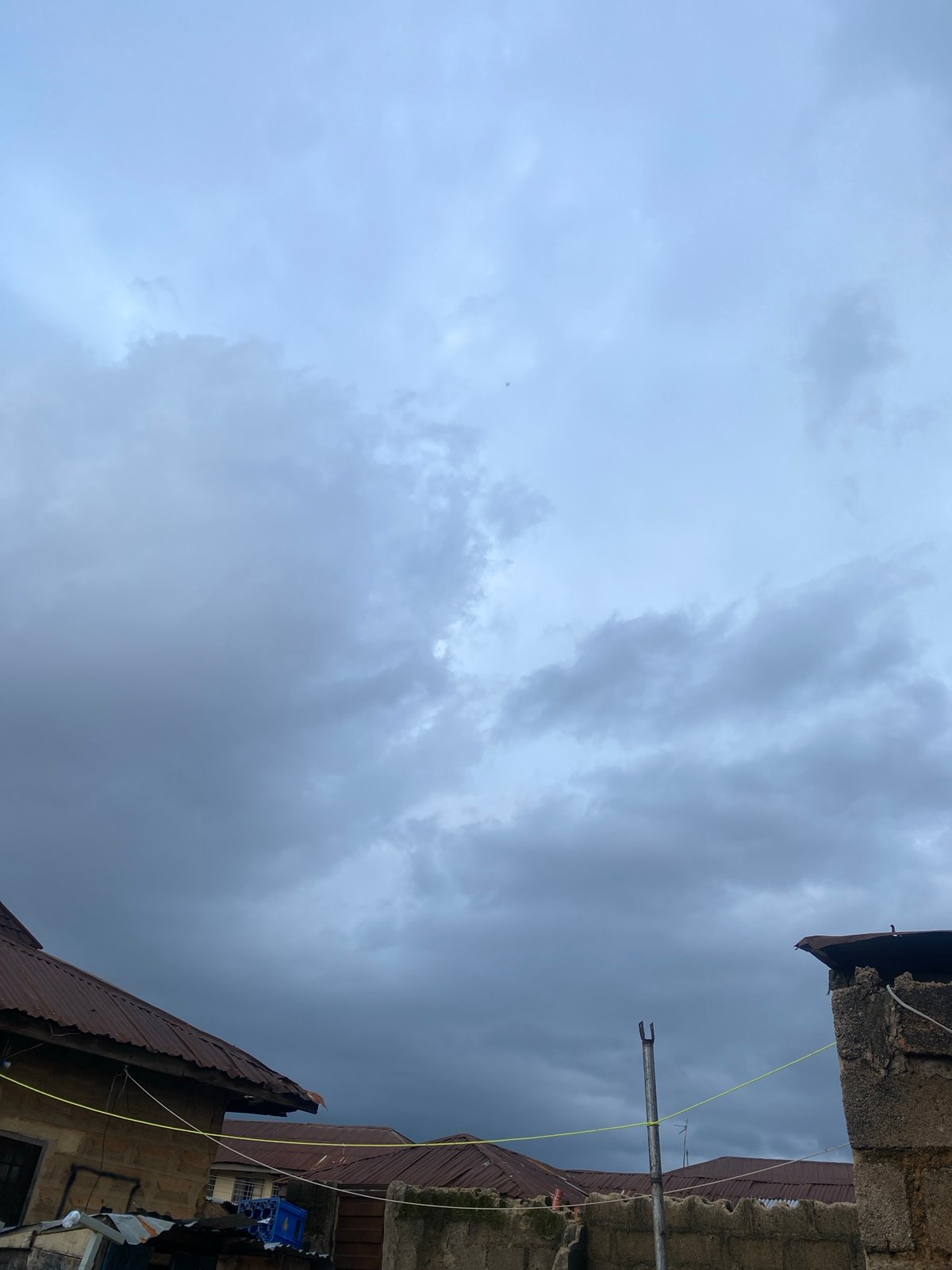 Street life and overcast skies across a Jos neighborhood