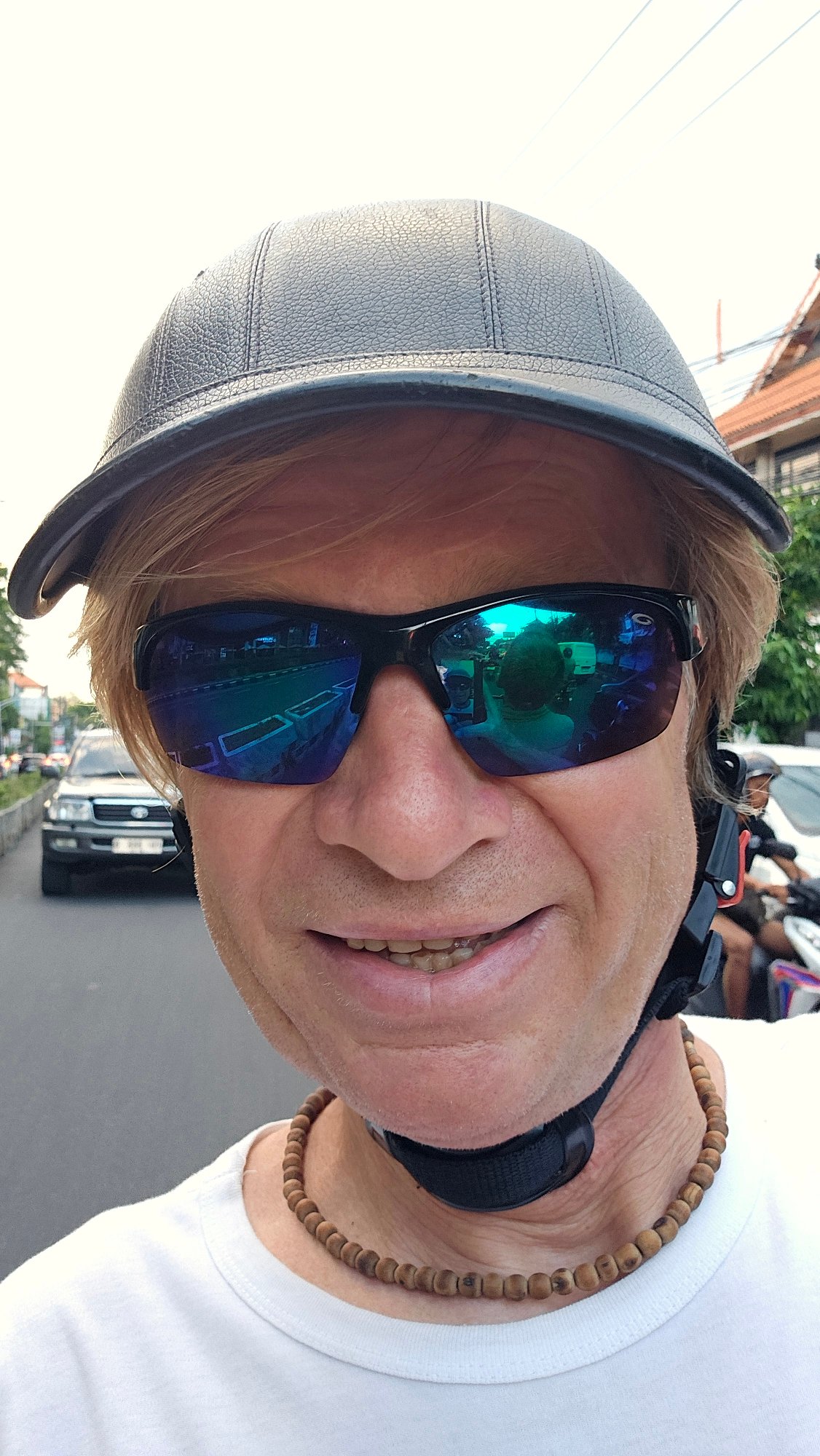 Motorcycle rider navigates morning traffic in Denpasar, Indonesia