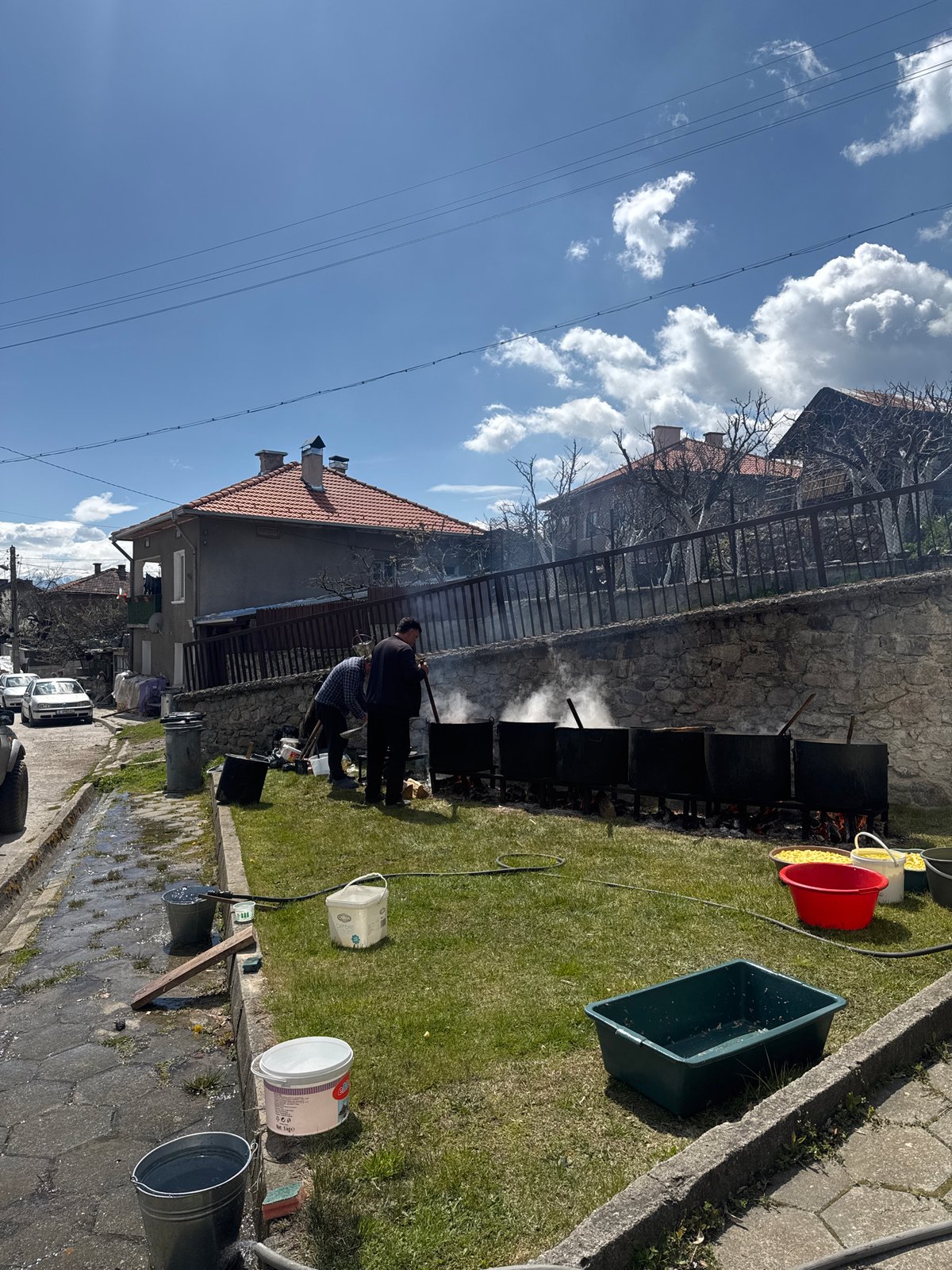 Two men tend fire with containers in Dobarsko