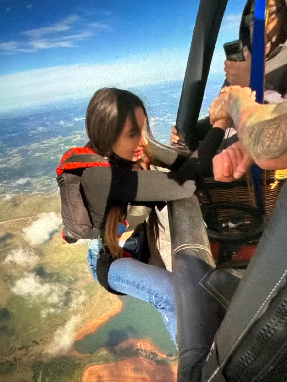 Group skydiving operation captured during helicopter jumps over city