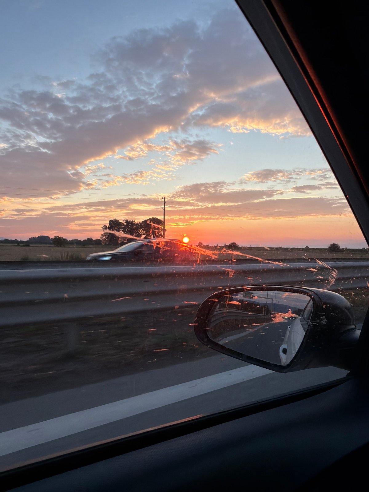 Colorful sunset sky over Kazichene, seen from a moving vehicle.