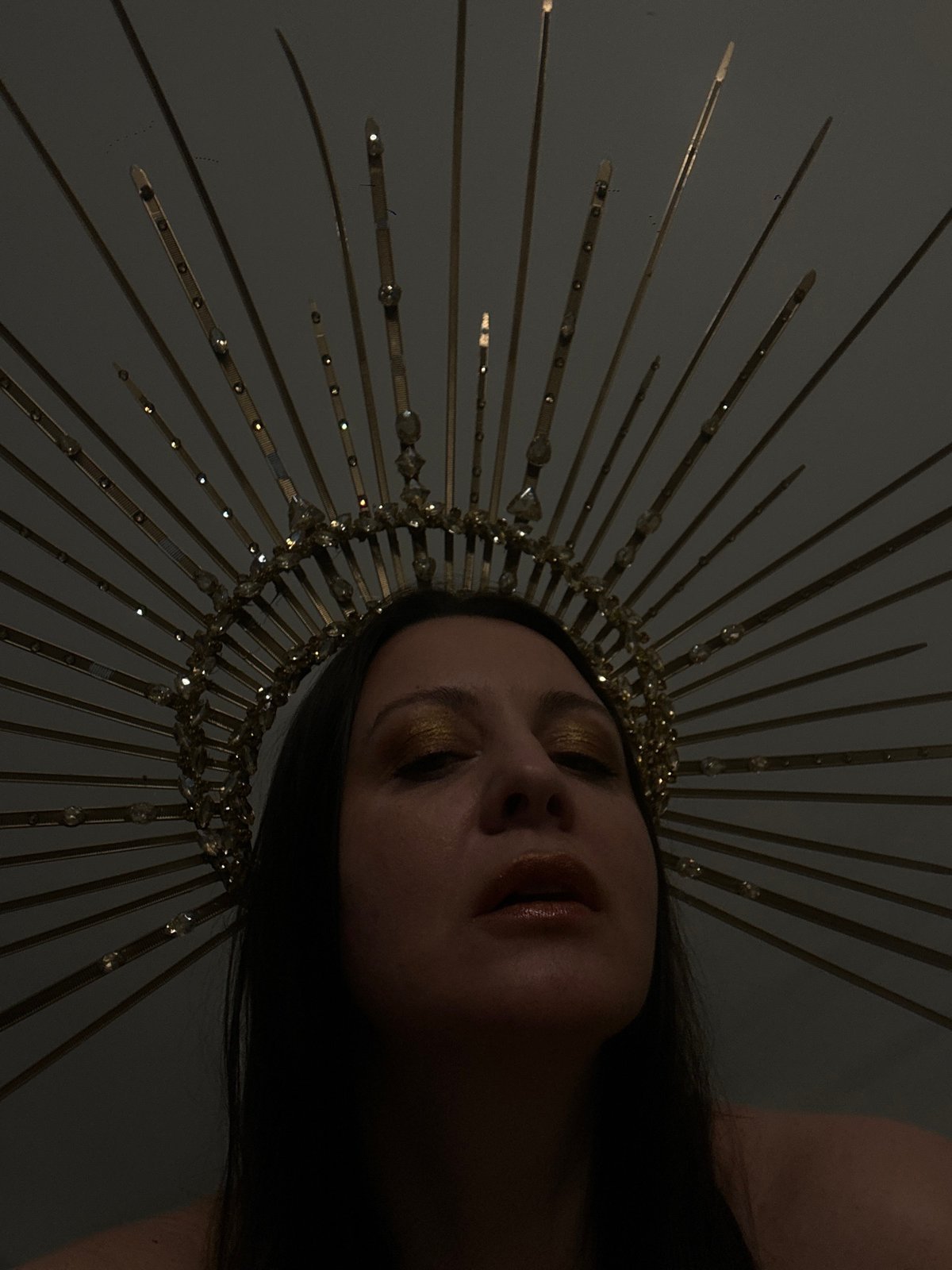 Person in golden crown photographed in elaborate portrait session