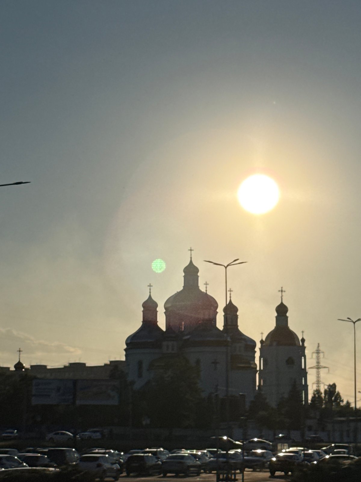 Golden-domed church silhouetted against a hazy sunset sky