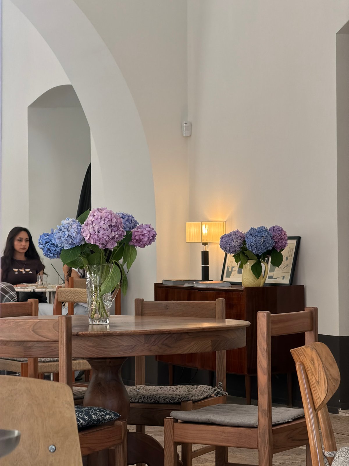 Inside a quiet Baku café, hydrangeas and pastries on display