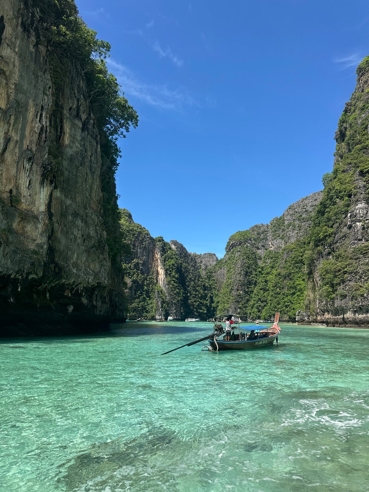 Long-tail boat anchored in a turquoise Haad Yao cove