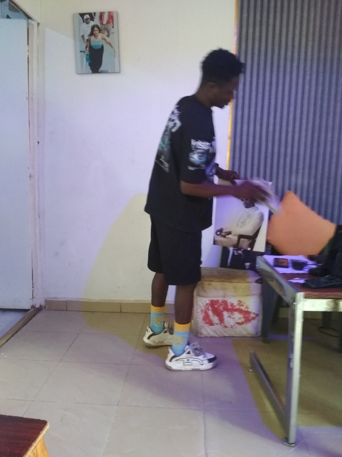 Person in black outfit observed handling object indoors