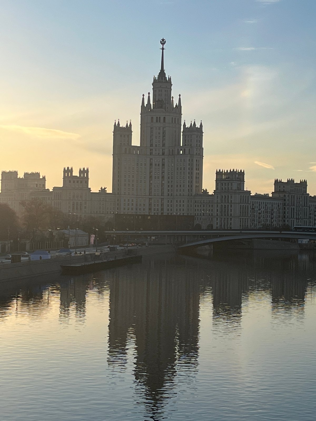 Seven Sisters skyscraper reflected in Moscow River at sunset