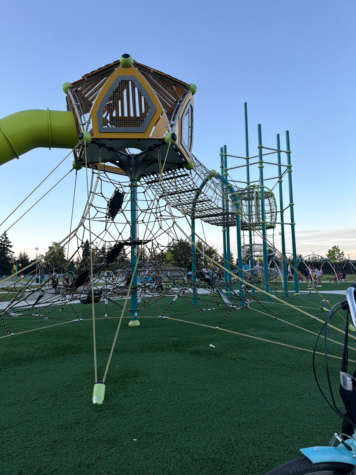 Playground and parked bicycle at an artificial turf recreational spot