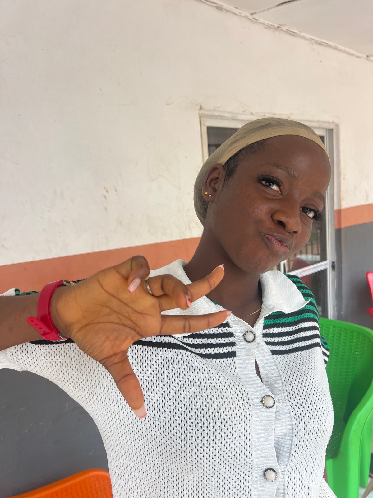 Portrait session in Nkpor, Nigeria, striped polo and orange chairs.