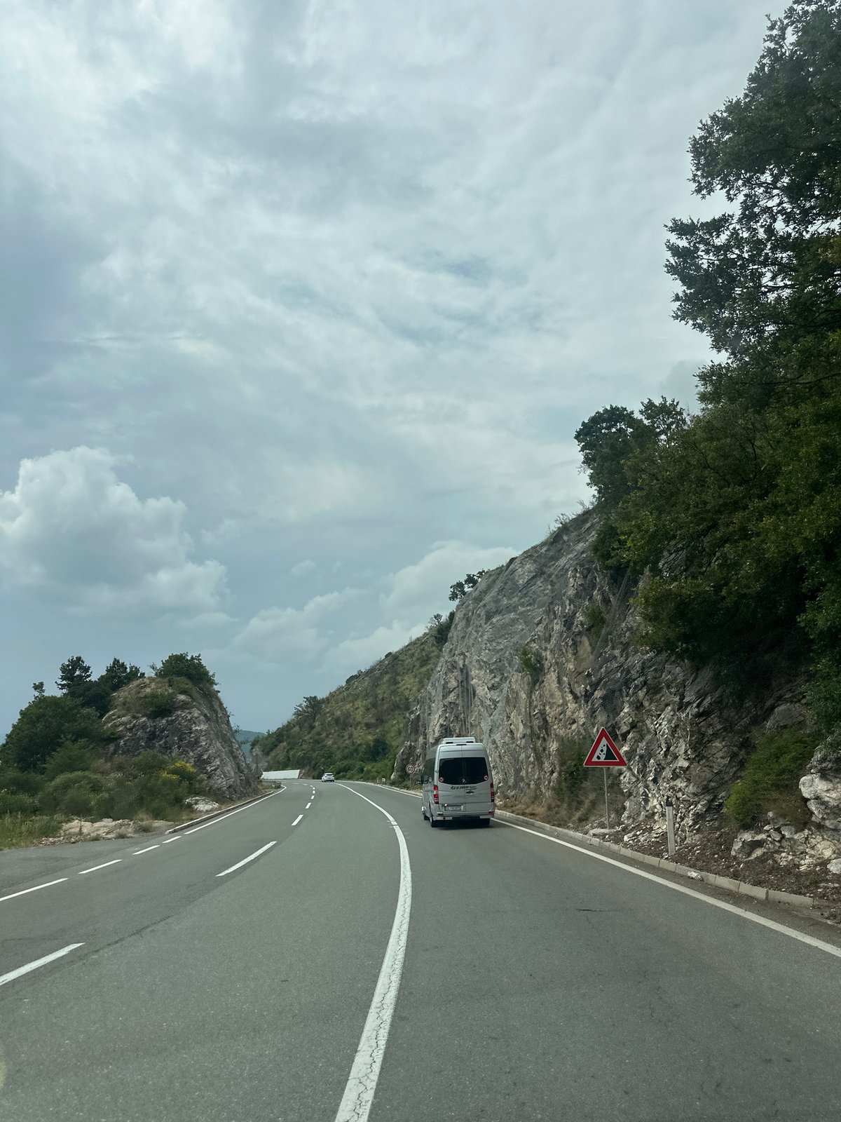 White camper van travels mountain road in Montenegro