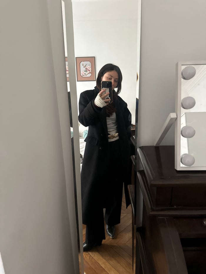 Woman takes mirror selfie in Paris clothing store