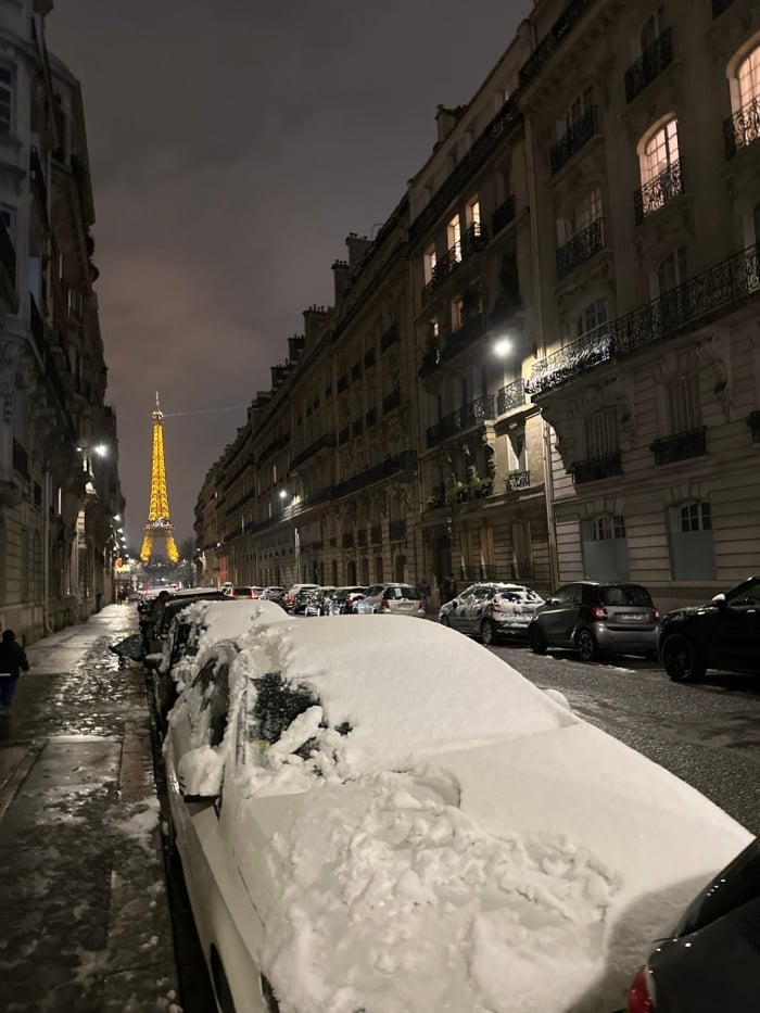Nighttime Paris street scene captures illuminated Eiffel Tower