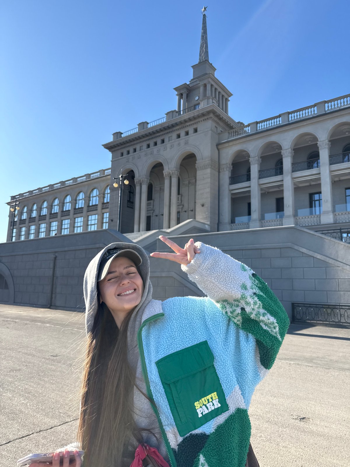 Woman poses near historic spired building in Krasnoyarsk