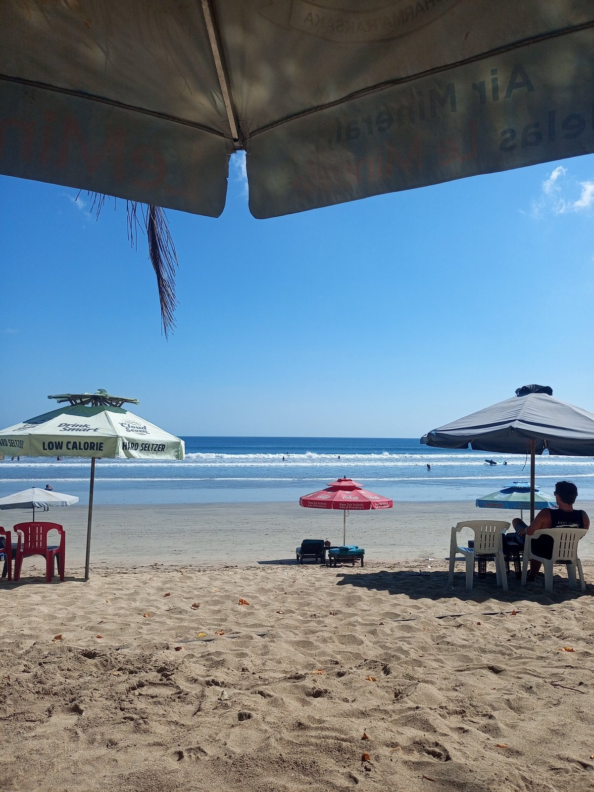Kuta Beach morning: surf racks, sand, and takeout noodles