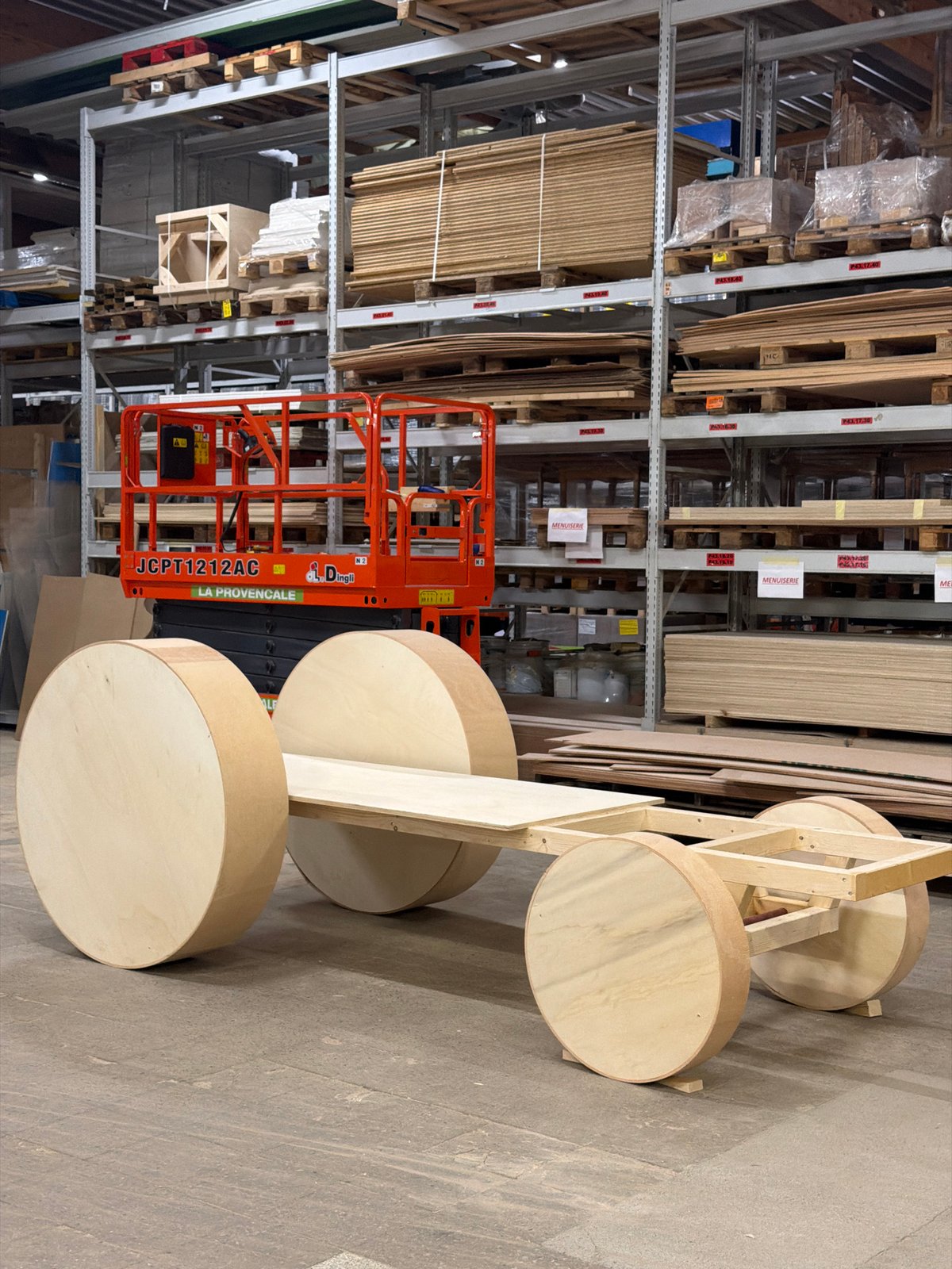Wooden vehicle prototype and tractor blueprints in a Luxembourg workshop