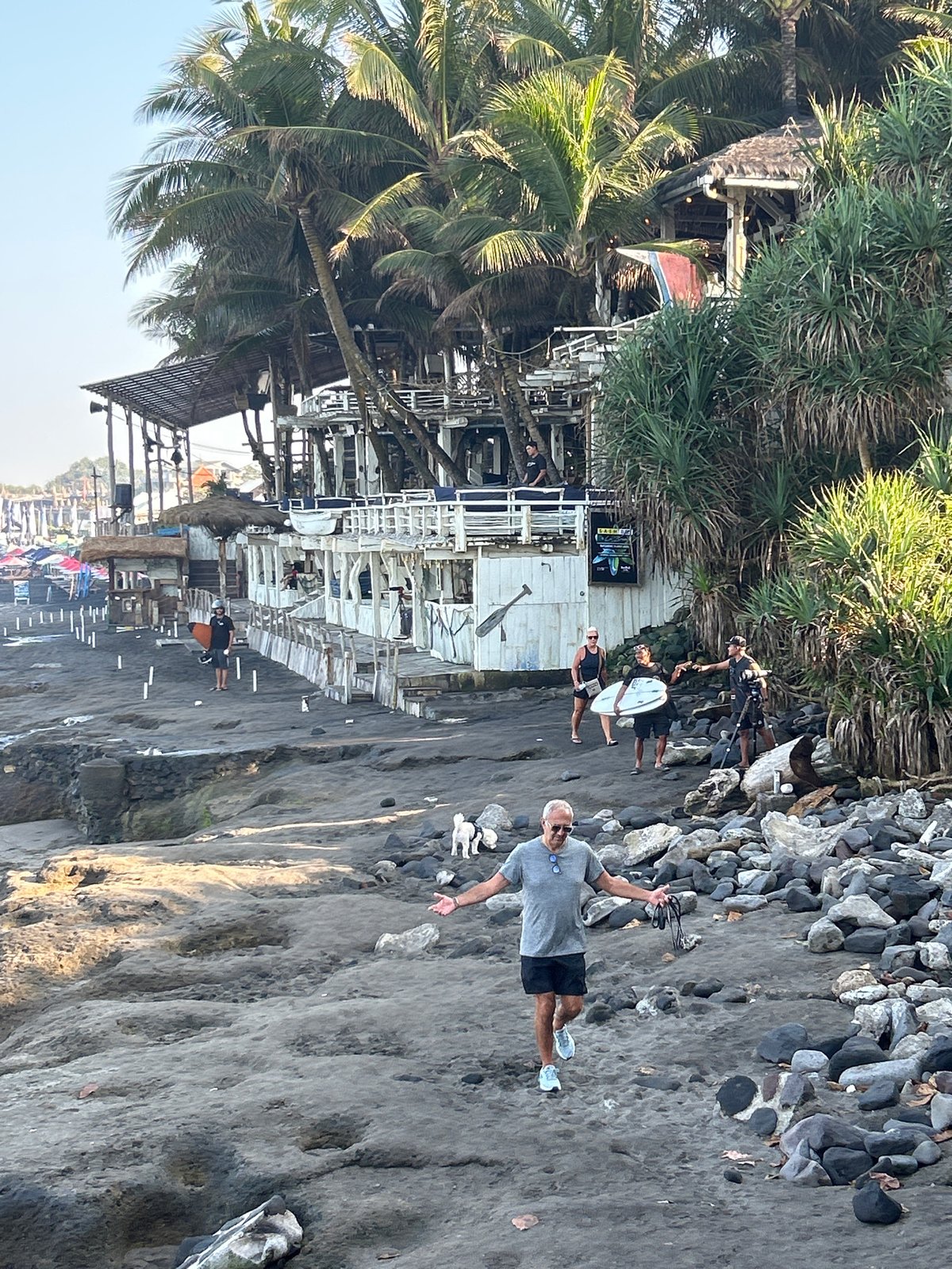 North Kuta black sand beach, surfers and beachgoers on a clear day