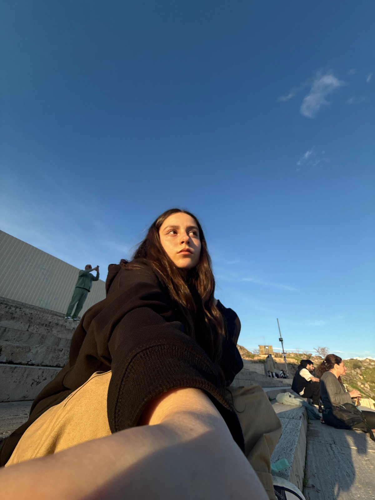 Tourist documents golden hour city views from Yerevan overlook