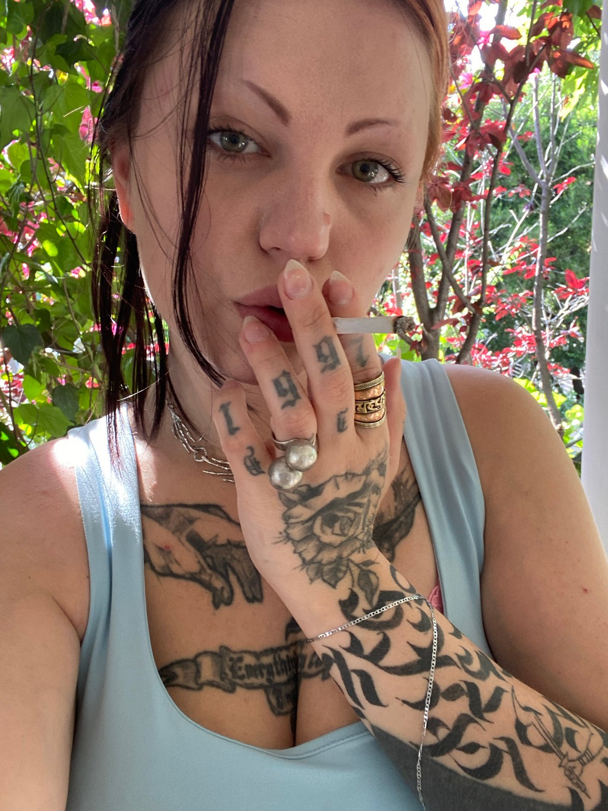 Tattooed woman smoking cigarette observed in Kunje, Montenegro