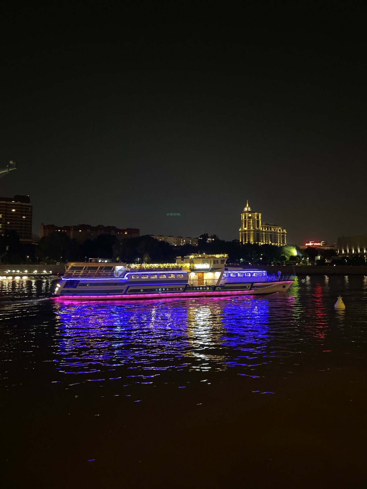 Colorful illuminated boat cruises Moscow River at night