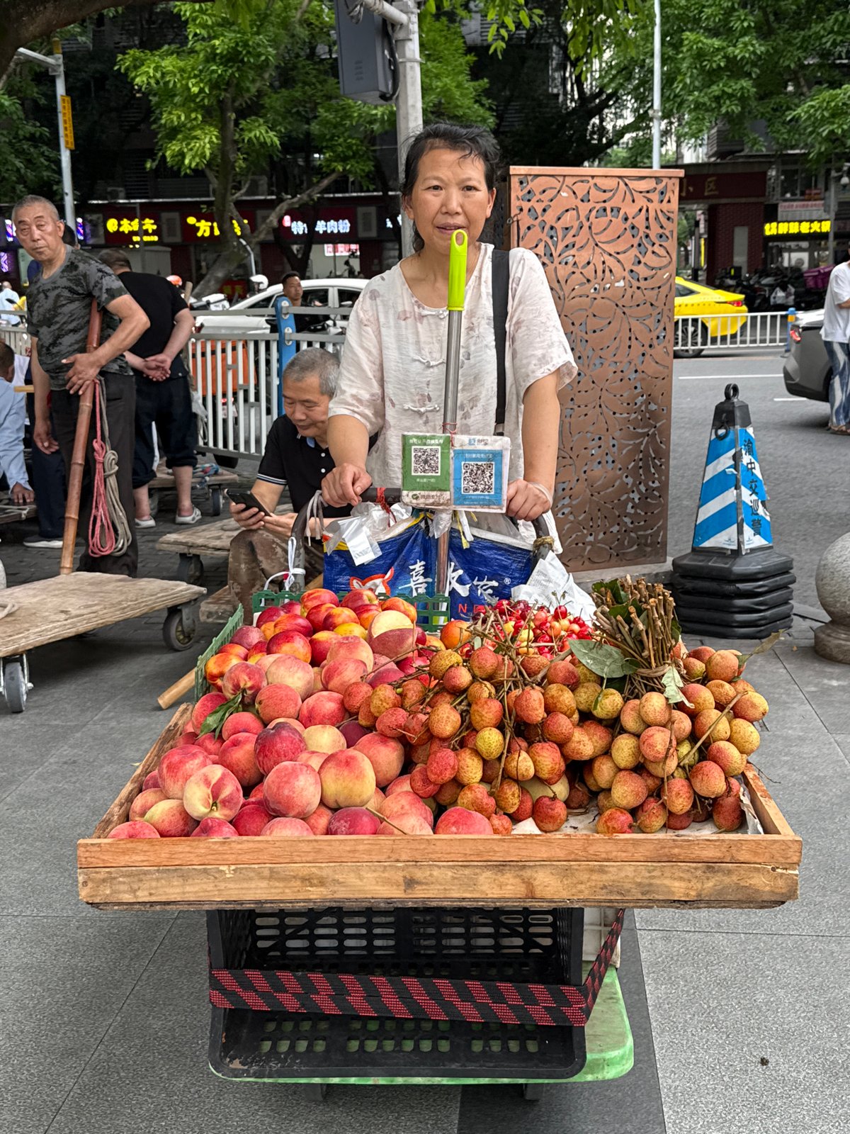 Fruit vendor sells peaches and lychees in Yuzhong District