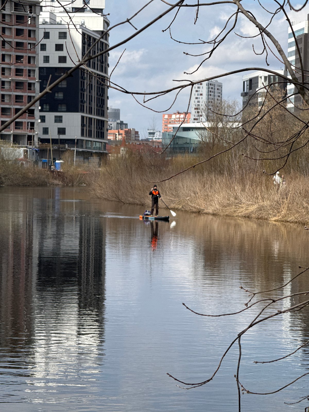 Paddleboarder spotted on Yekaterinburg waterway amid urban landscape