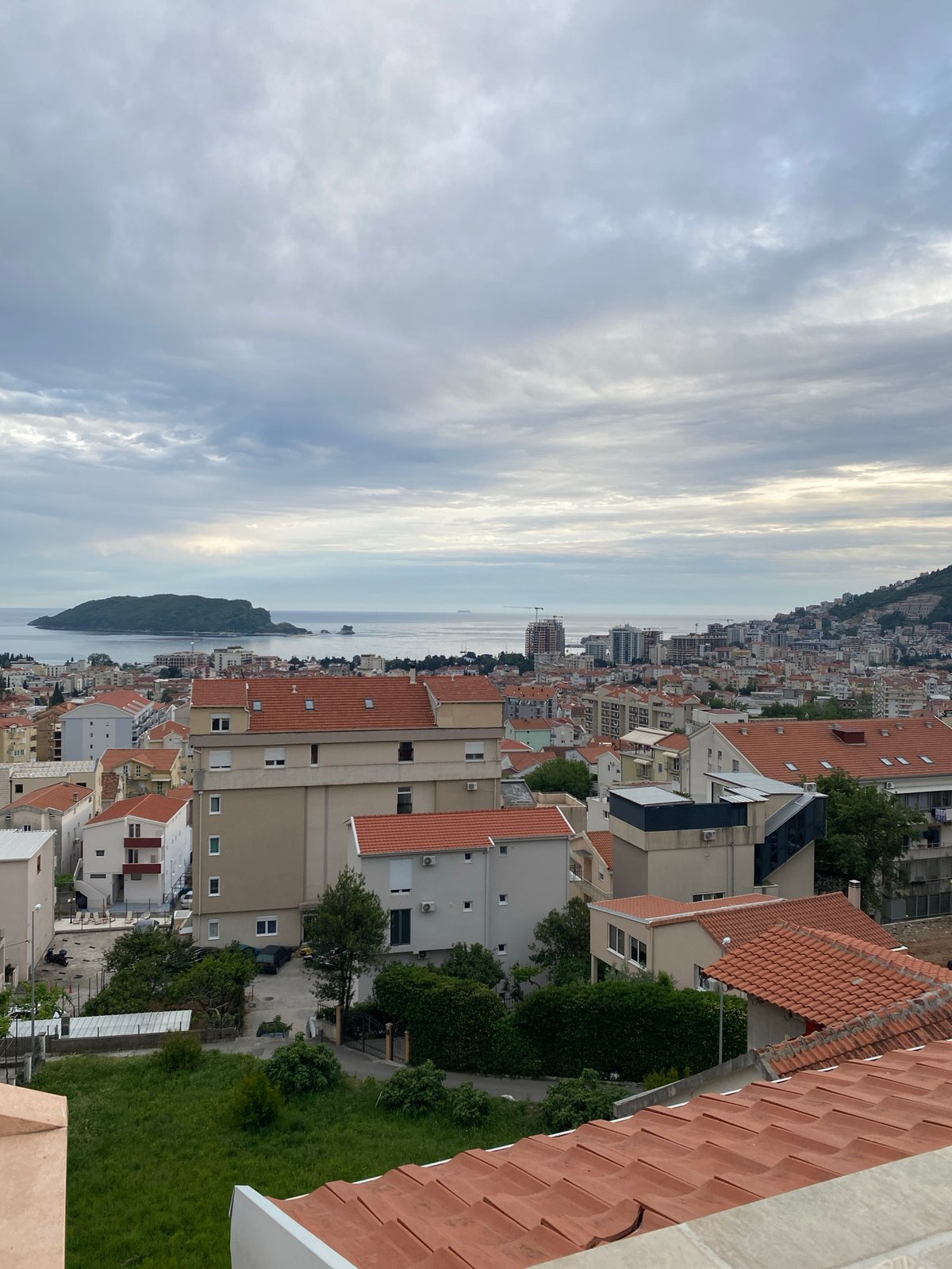 Aerial views capture Budva's coastline and architecture under cloudy skies
