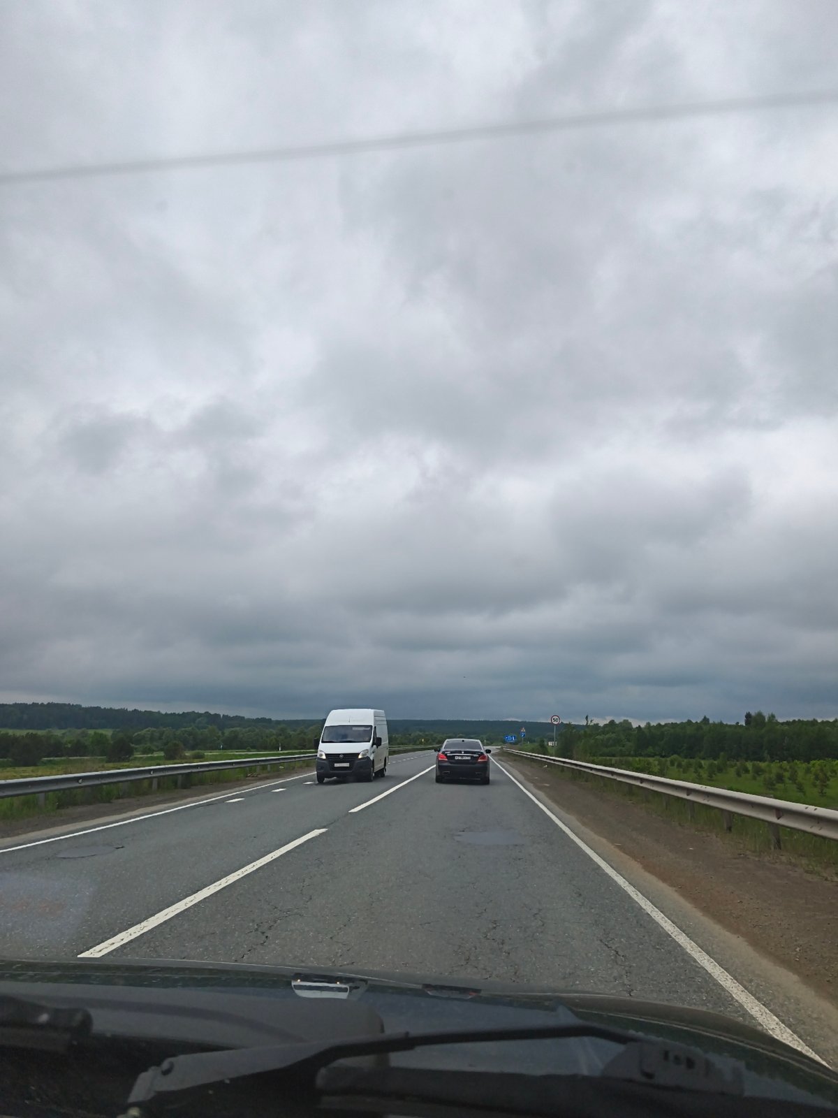 Vehicle travels Russian highway under overcast morning skies
