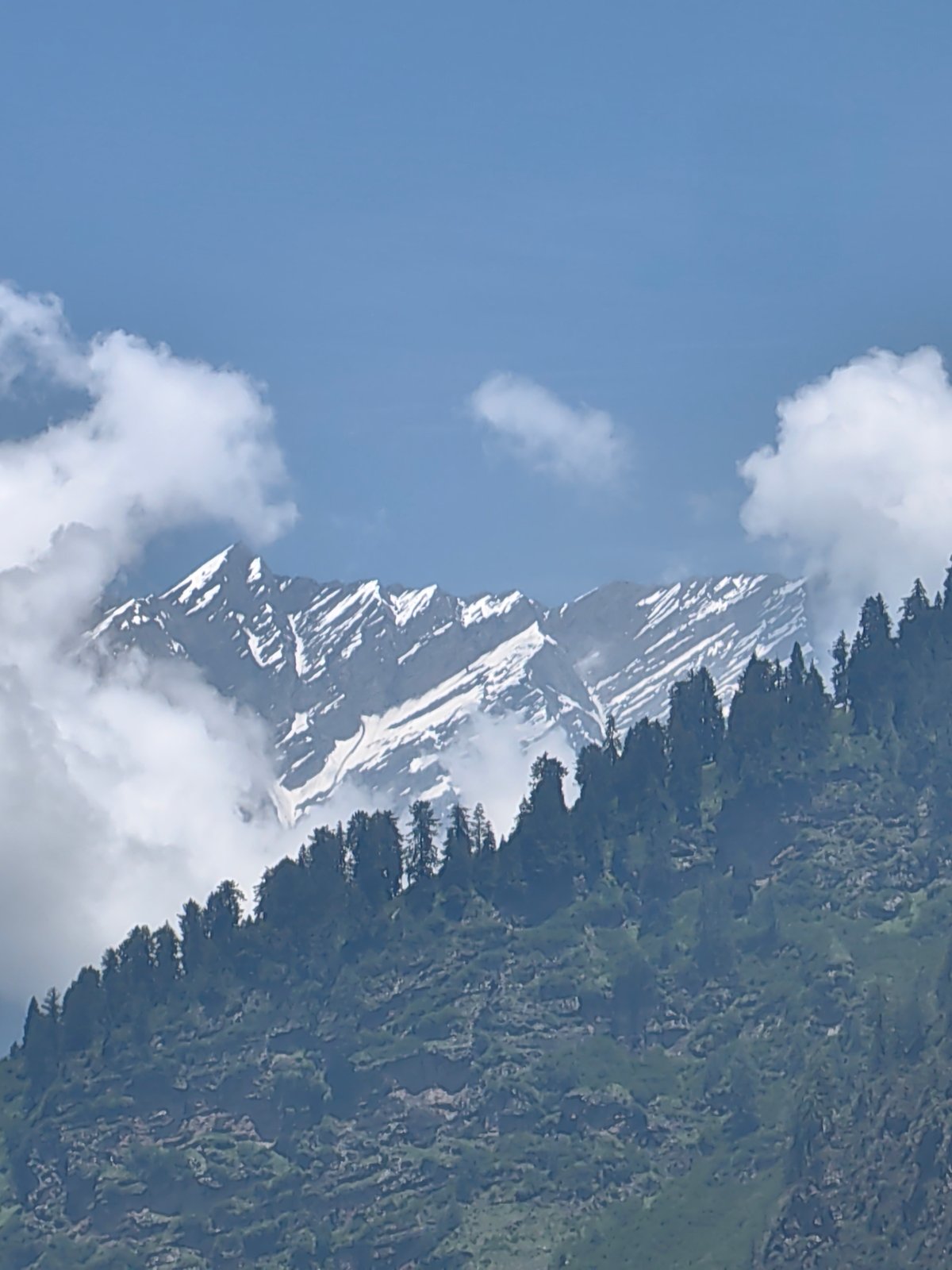Cloud-wrapped Himalayan peaks near Kulang on a clear morning