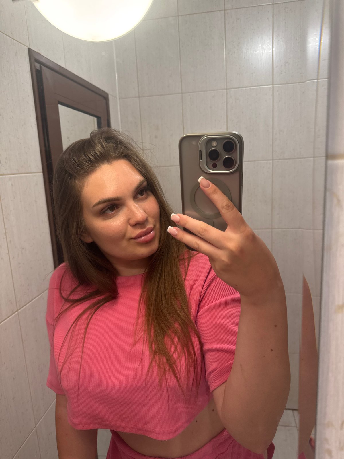 Mirror selfies in a Sofia bathroom, pink outfit, July 2026