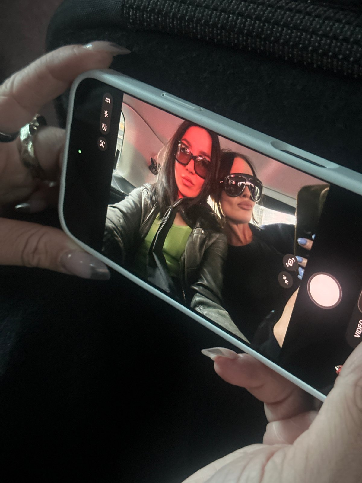 Person photographed holding white iPhone in London