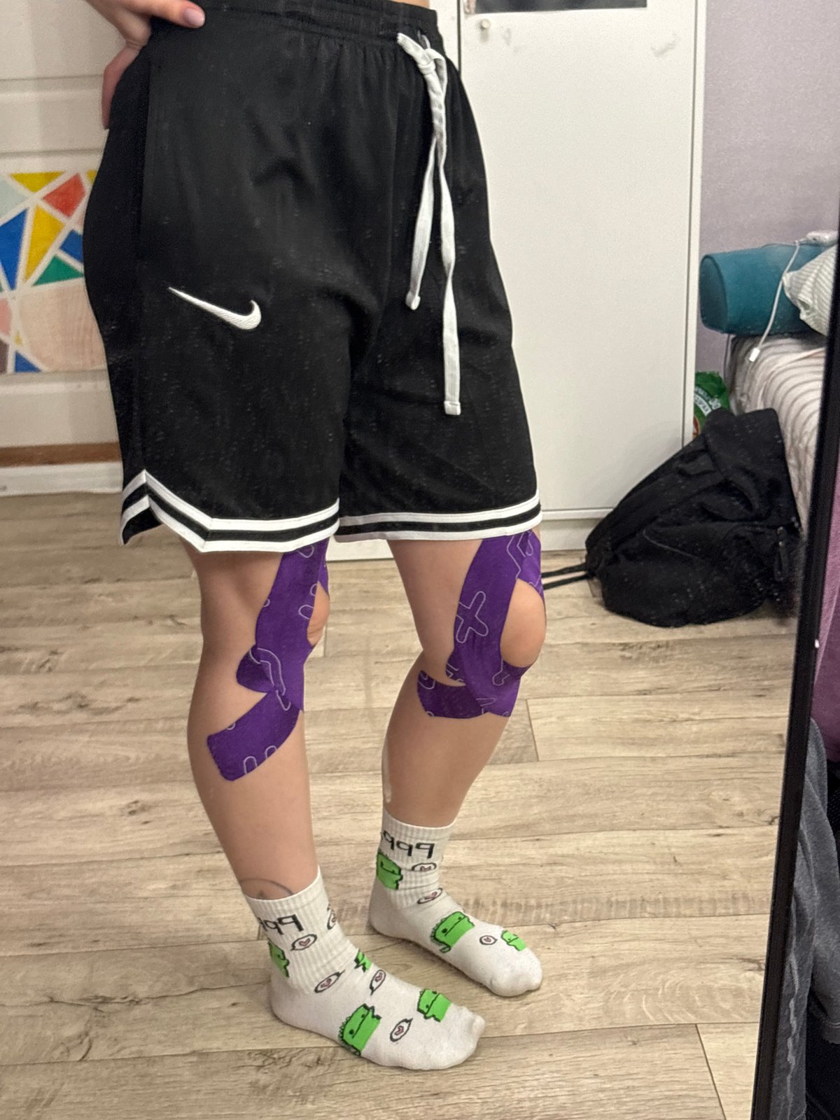 Athlete spotted with purple kinesiology tape on both knees