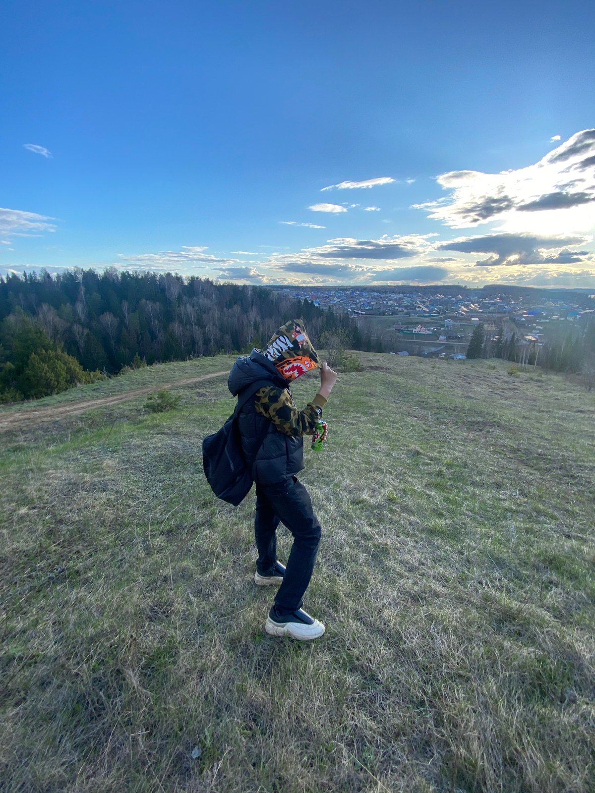Person observed on hillside overlooking town during afternoon hours