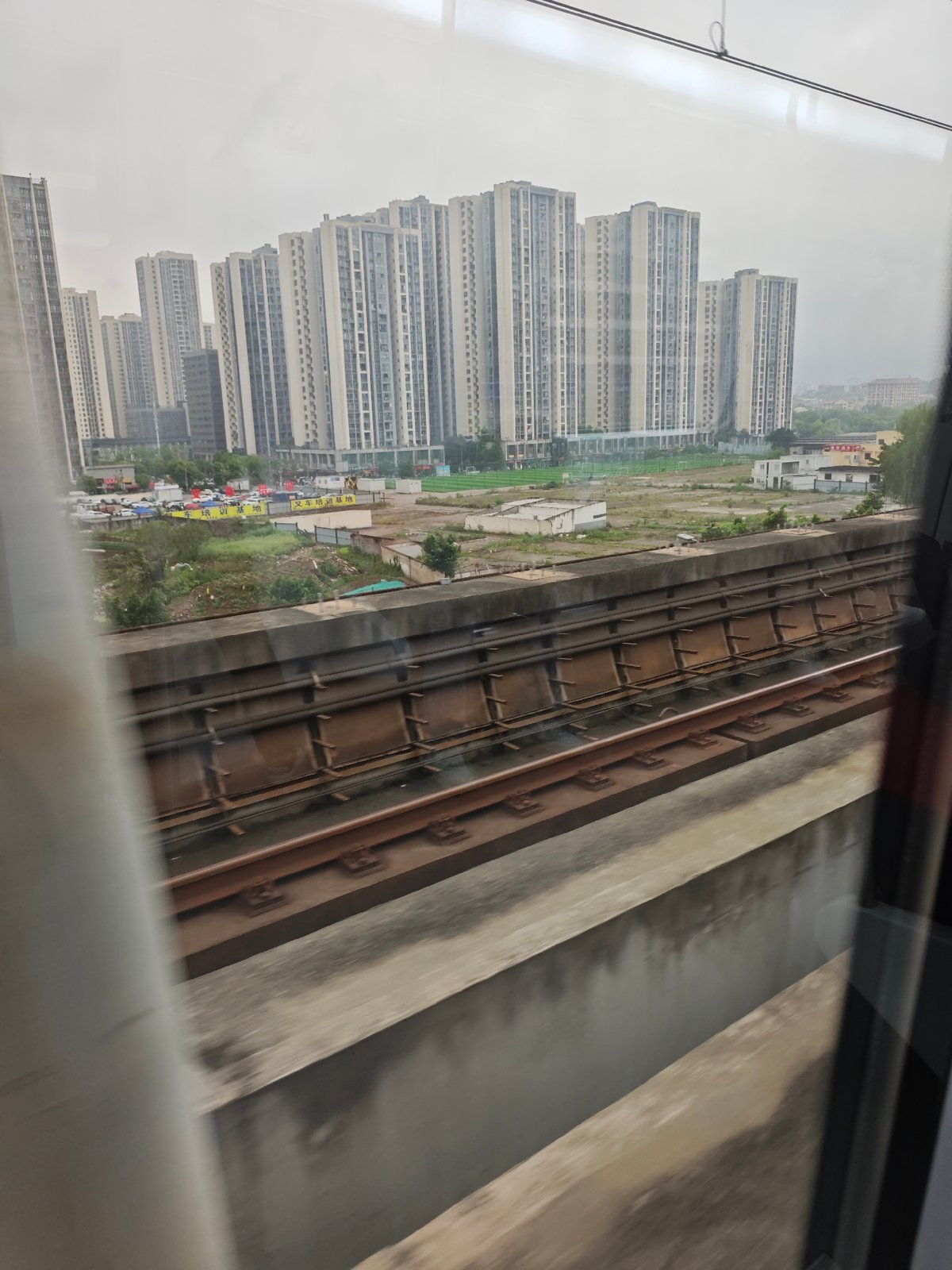 Train passenger photographs Chongqing apartment towers from window