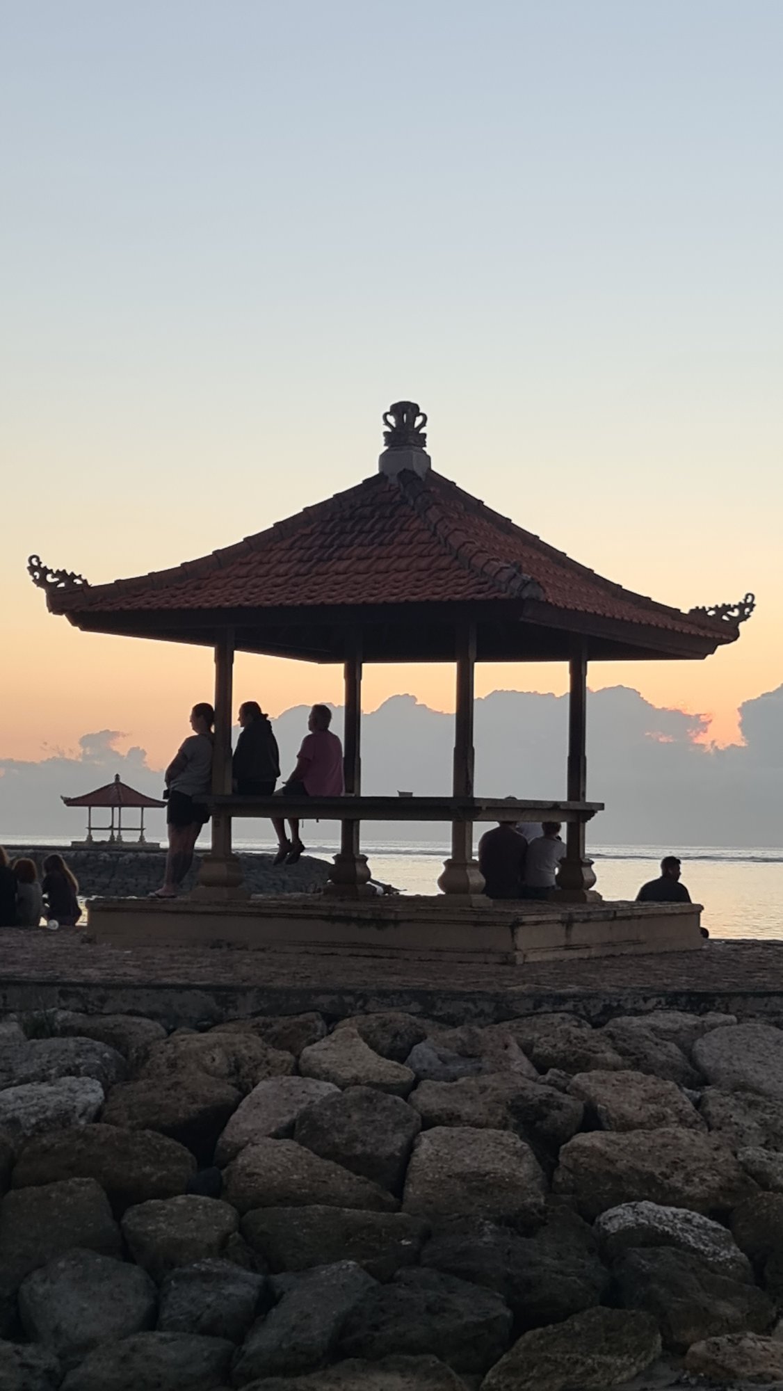 Sanur Beach at golden hour, boats, rocks, and quiet shoreline moments