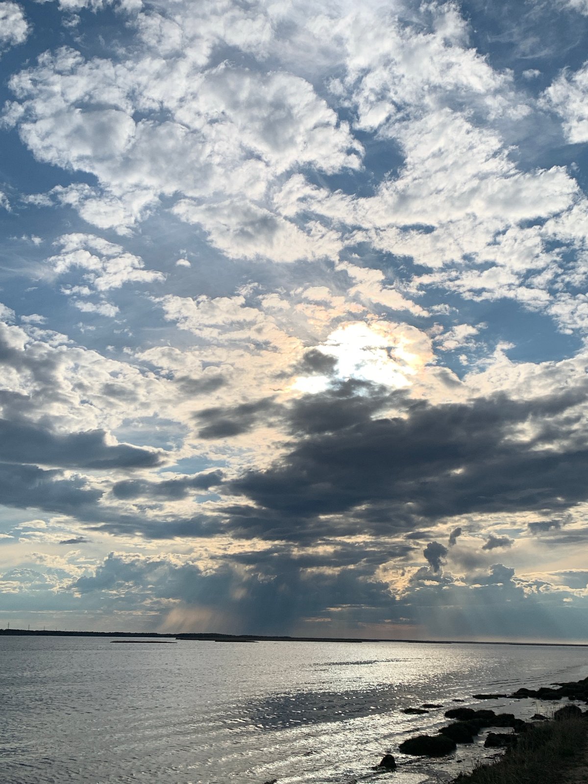 Train passes waterfront under cloudy skies in Severodvinsk