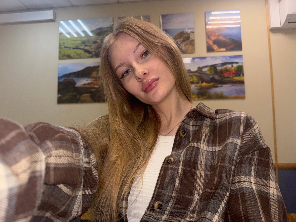 Woman takes selfies in plaid shirt in Perm apartment