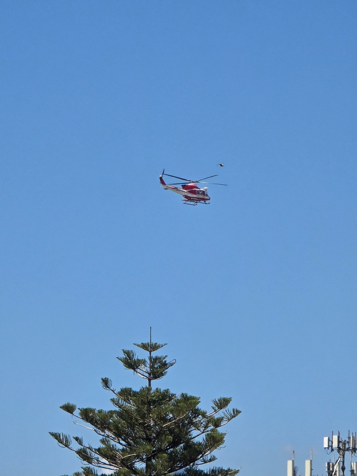 Red and white helicopter over Salerno on a clear morning