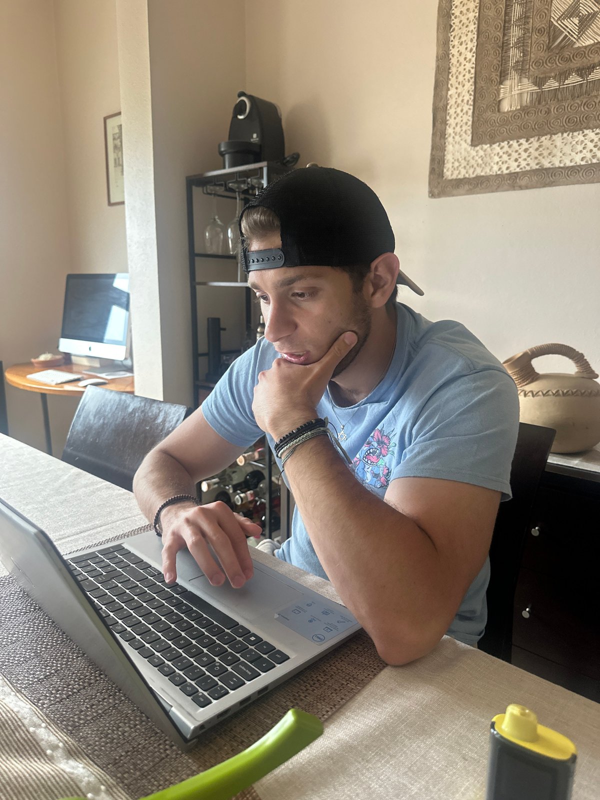 Person works on laptop while eating soup in Mexico
