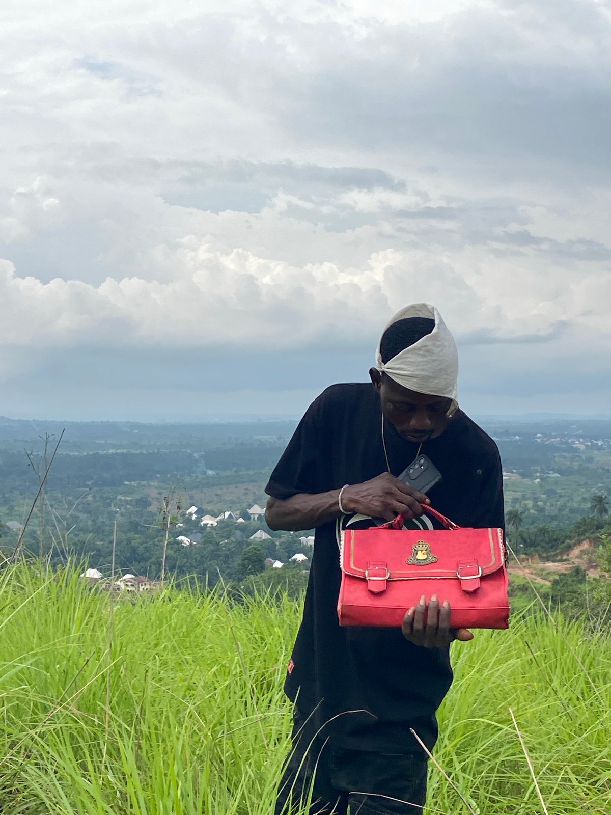 Person with red bag observed on hillside in Achara, Nigeria