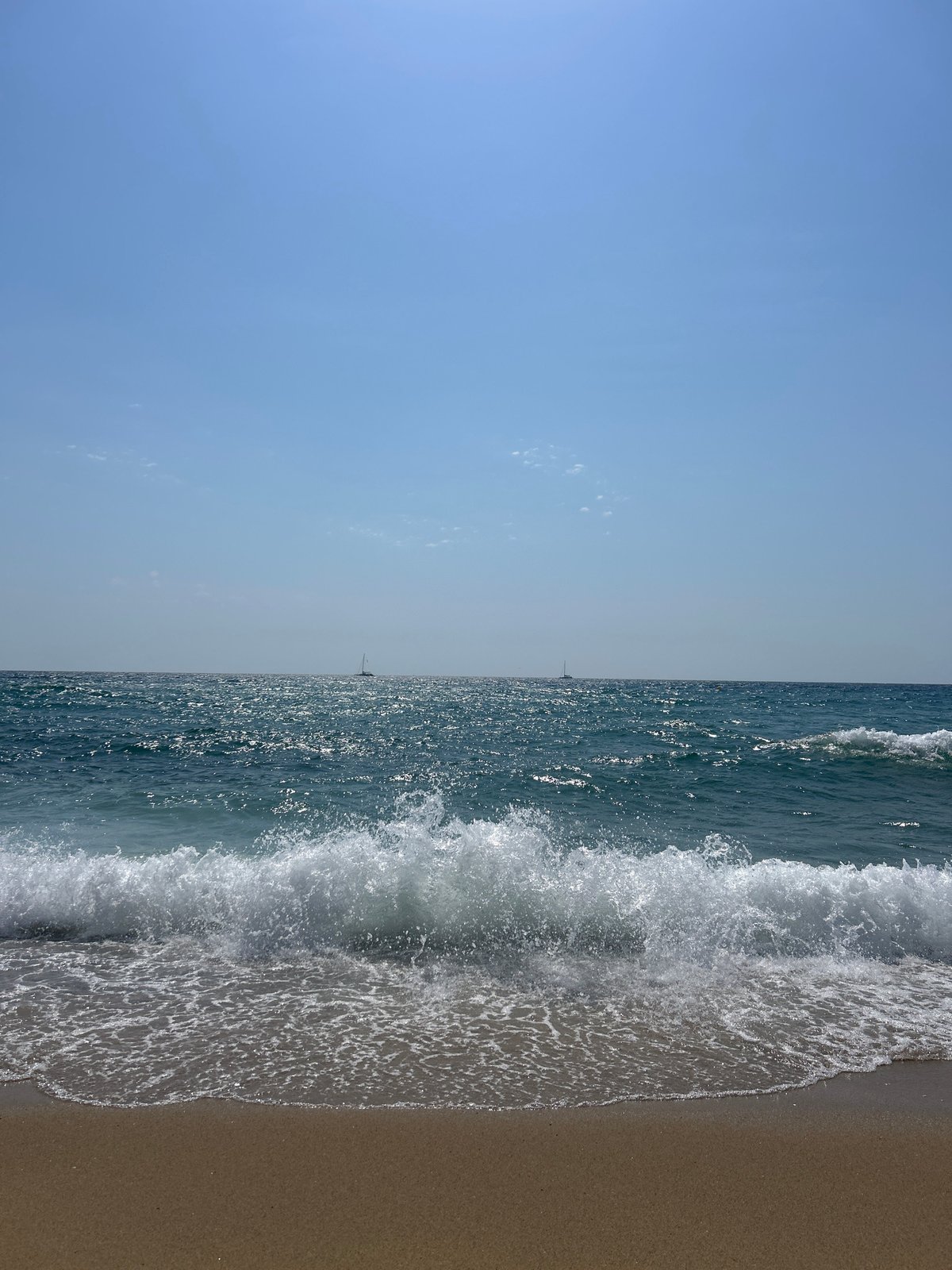 Barcelona beach morning: waves, sailboats, and a passing helicopter