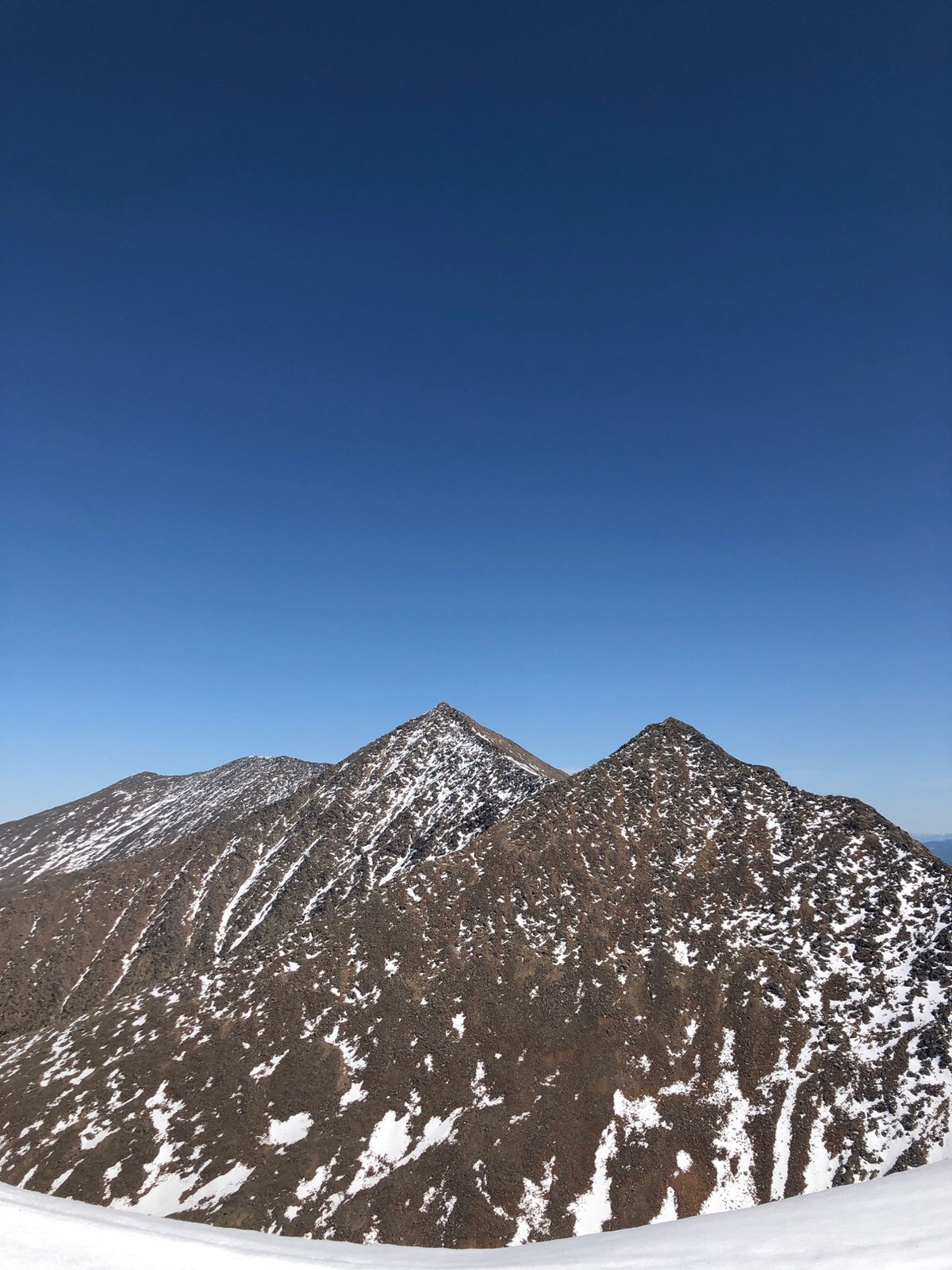 Snow-capped mountains observed under clear blue skies in Russia