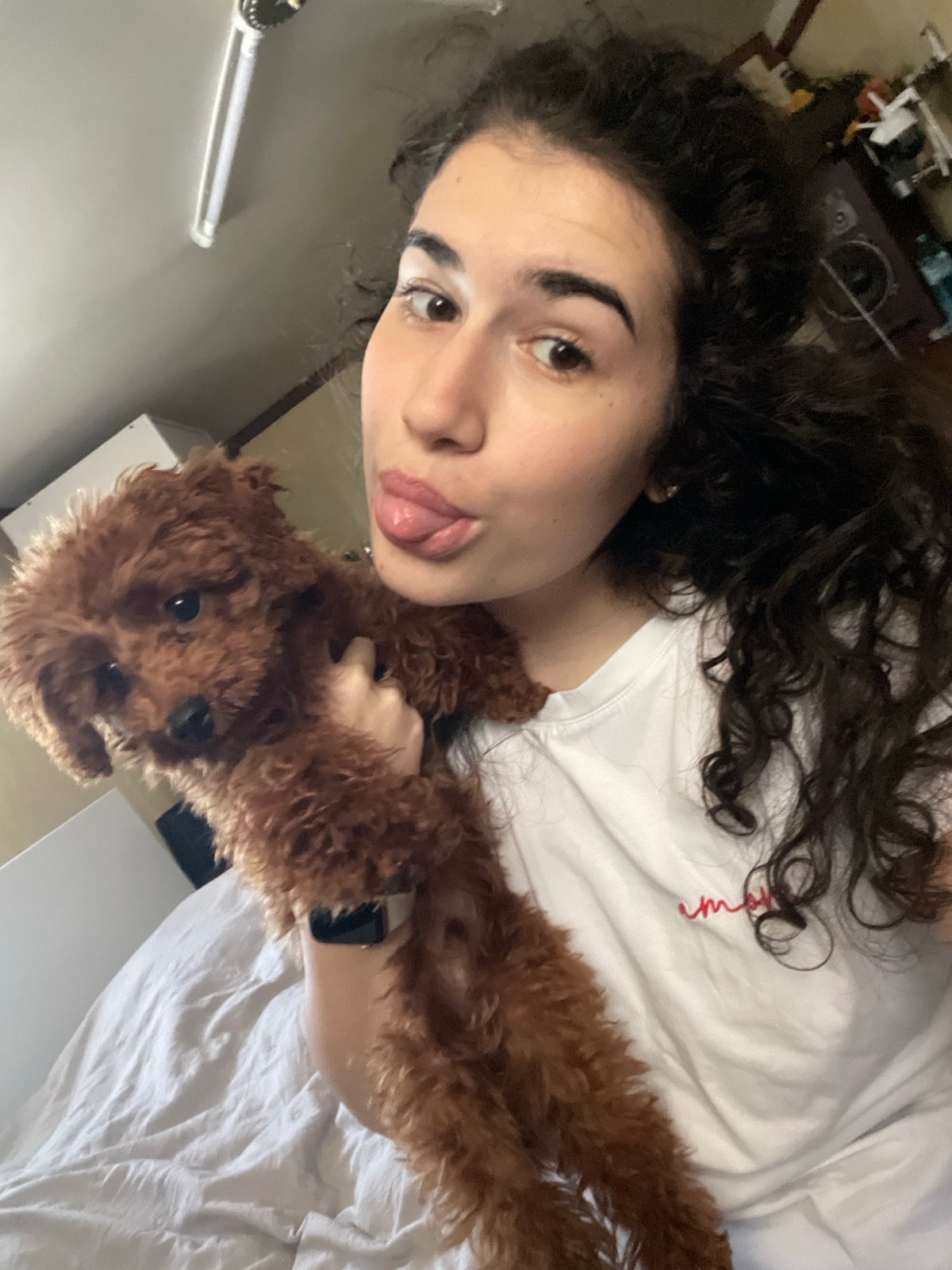 Woman poses playfully with poodle in Sofia apartment