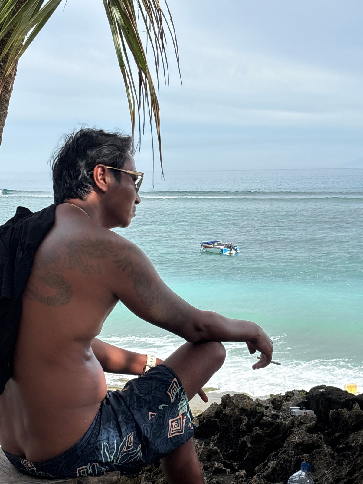 Beach activity documented in Kuta Selatan with surfer, boats