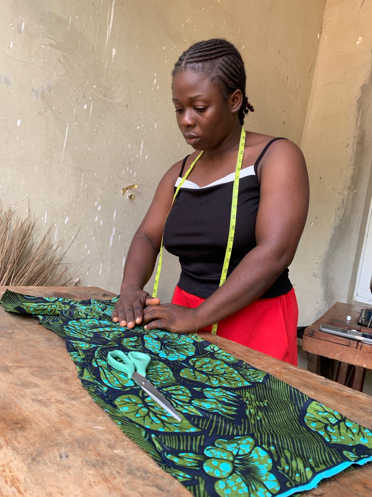 Measuring and sewing patterned fabric at a workshop in Akwanga