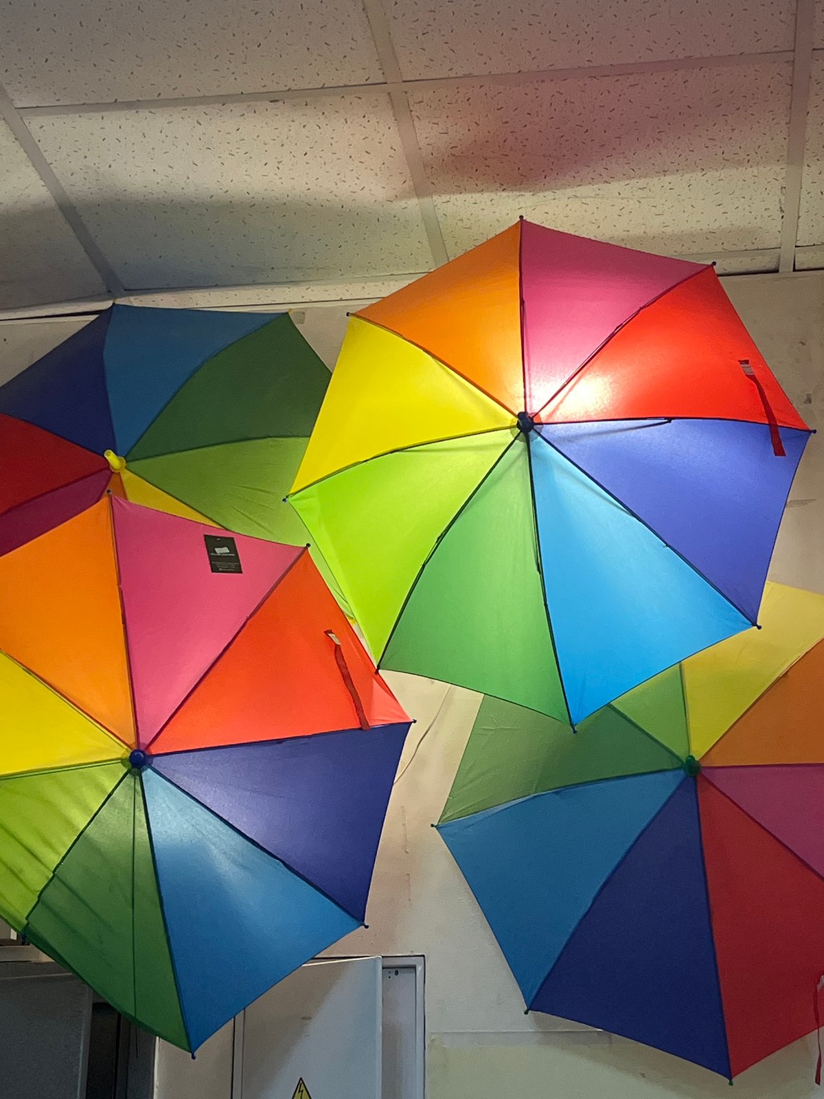 Rainbow umbrellas clustered indoors in Izhevsk, Russia